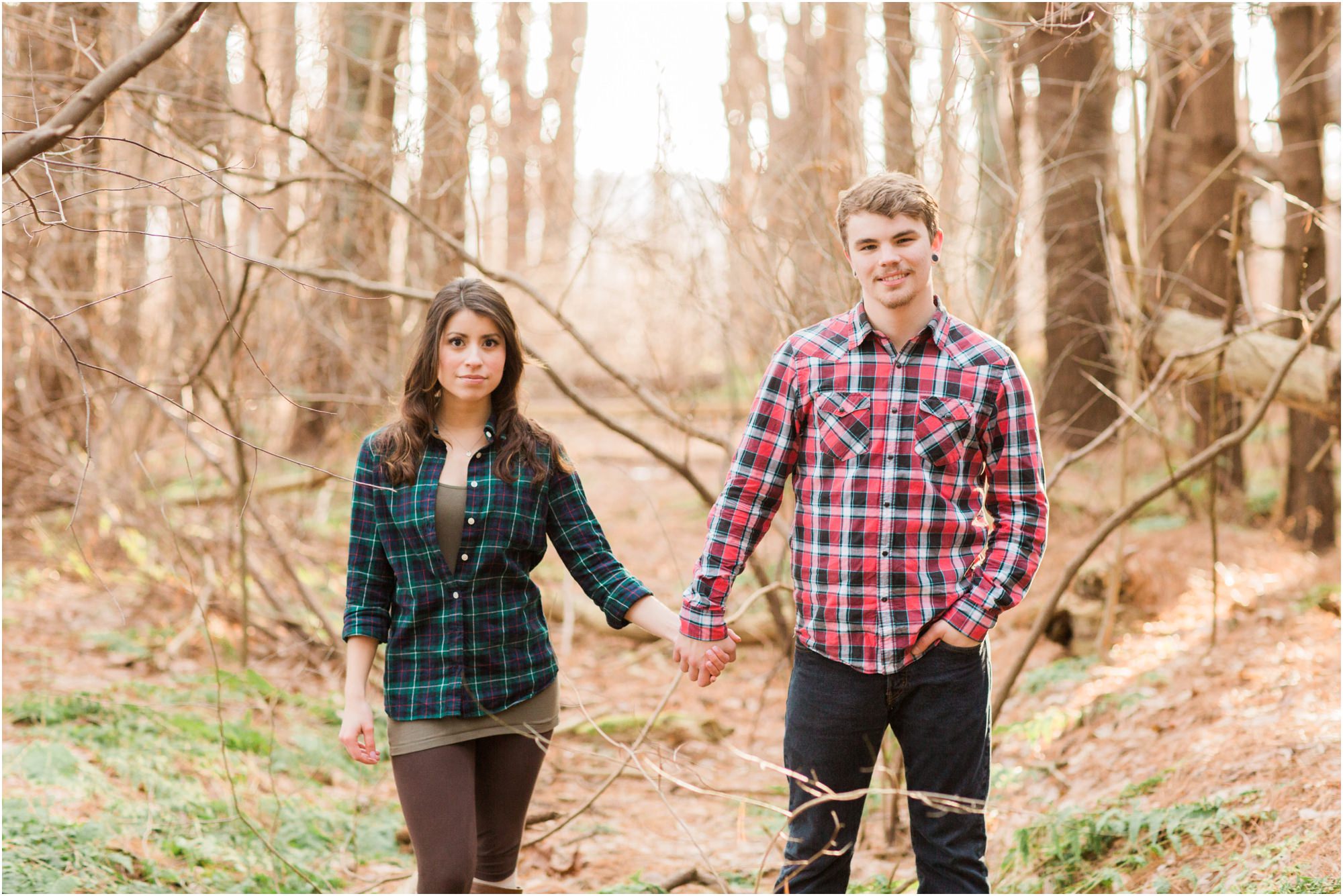 couple standing in woods at pillow fight engagement session