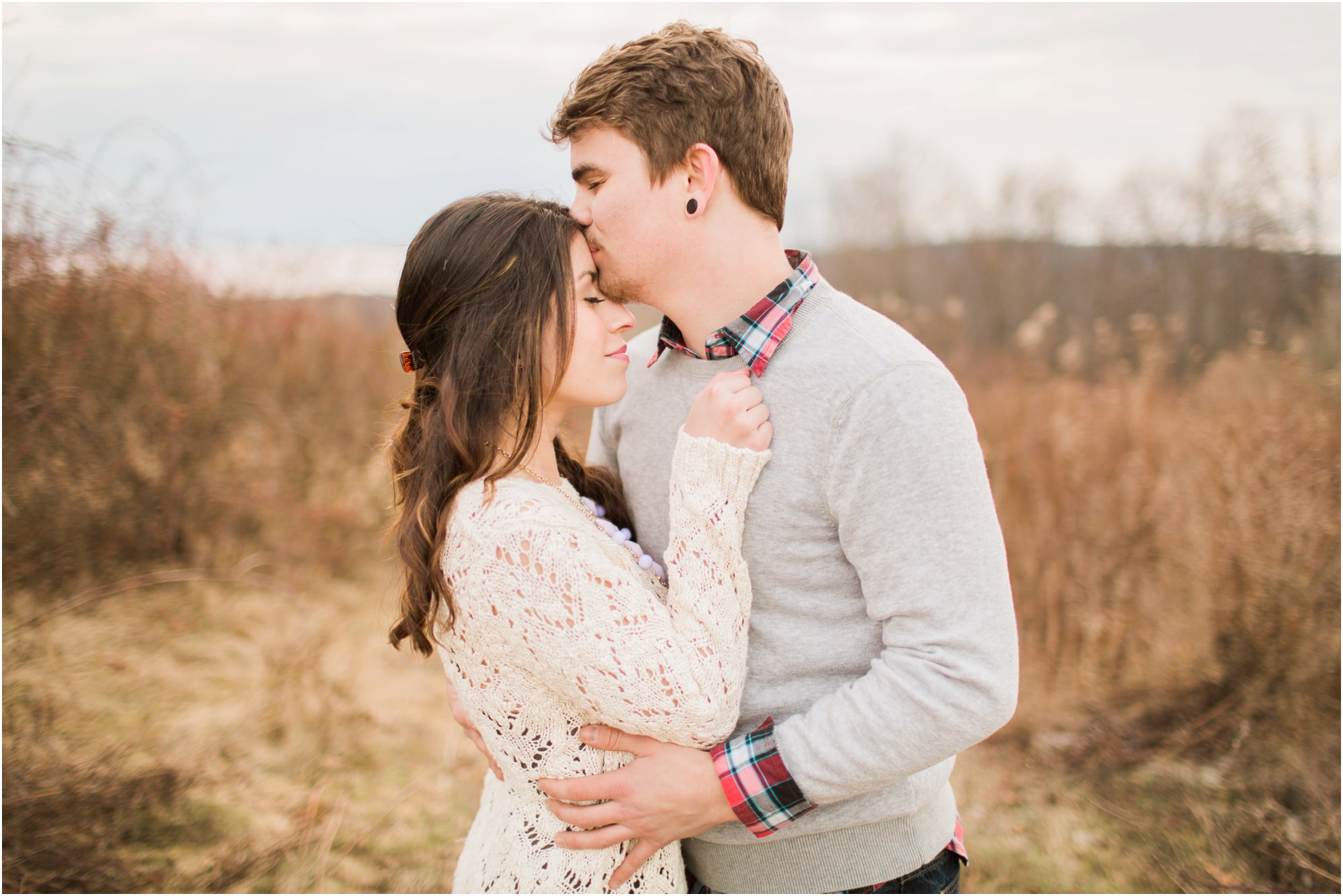Couple in a field after pillow fight engagement session