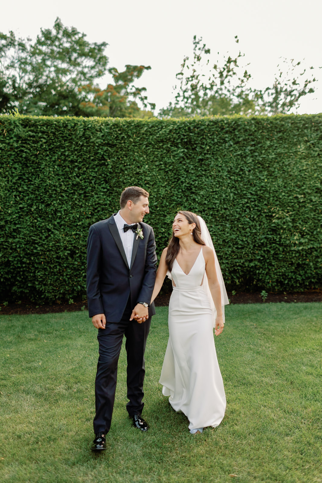 Summer wedding at The Roundhouse. Couple in wedding attire laughing while walking.