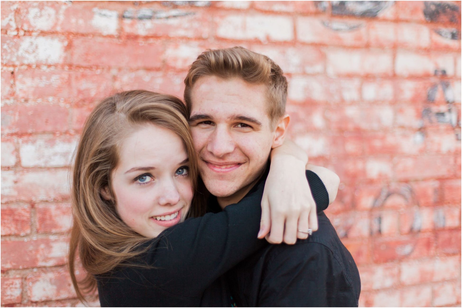 couple in front of old brick wall