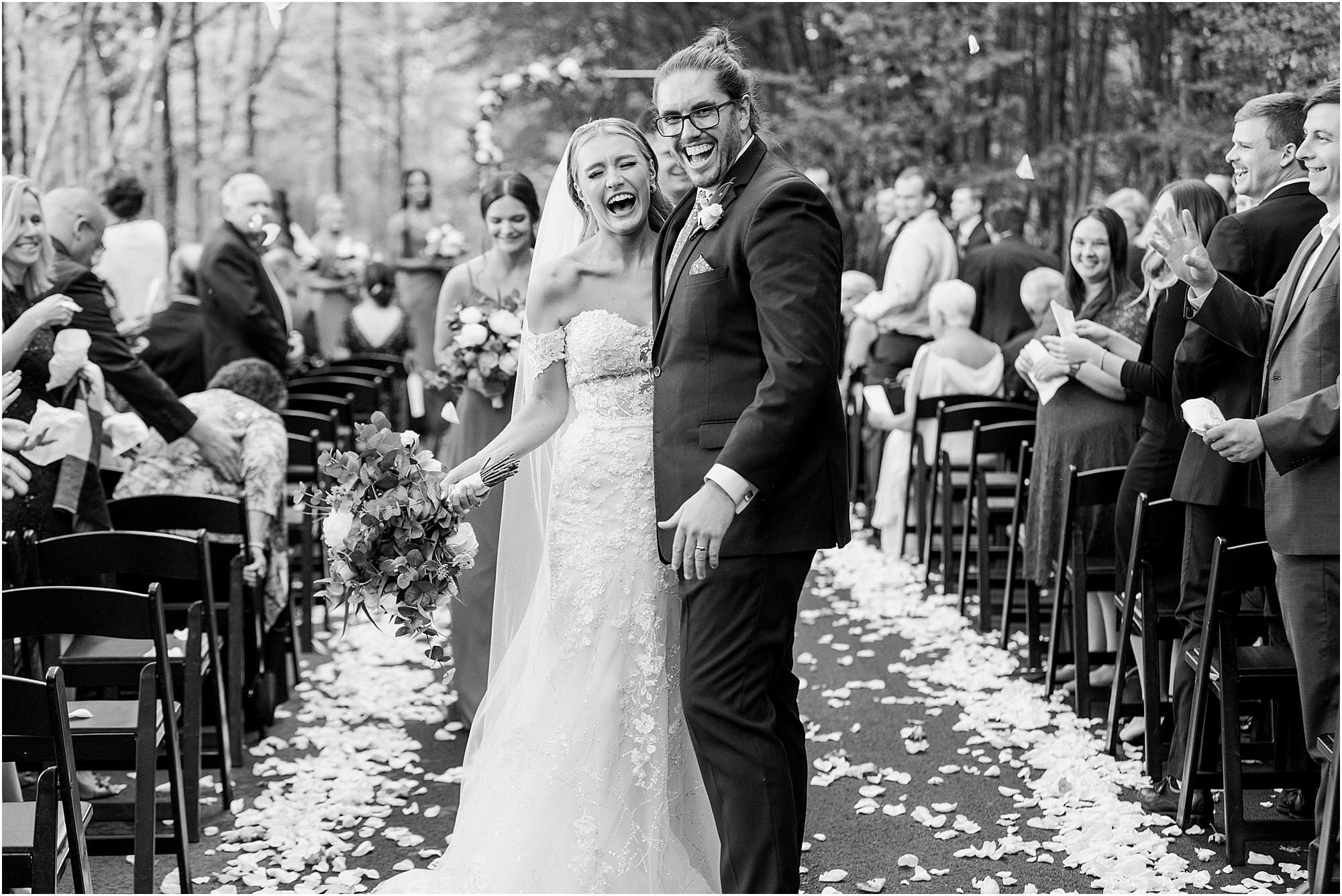 Bride and groom smiling at the end of the aisle after their recessional
